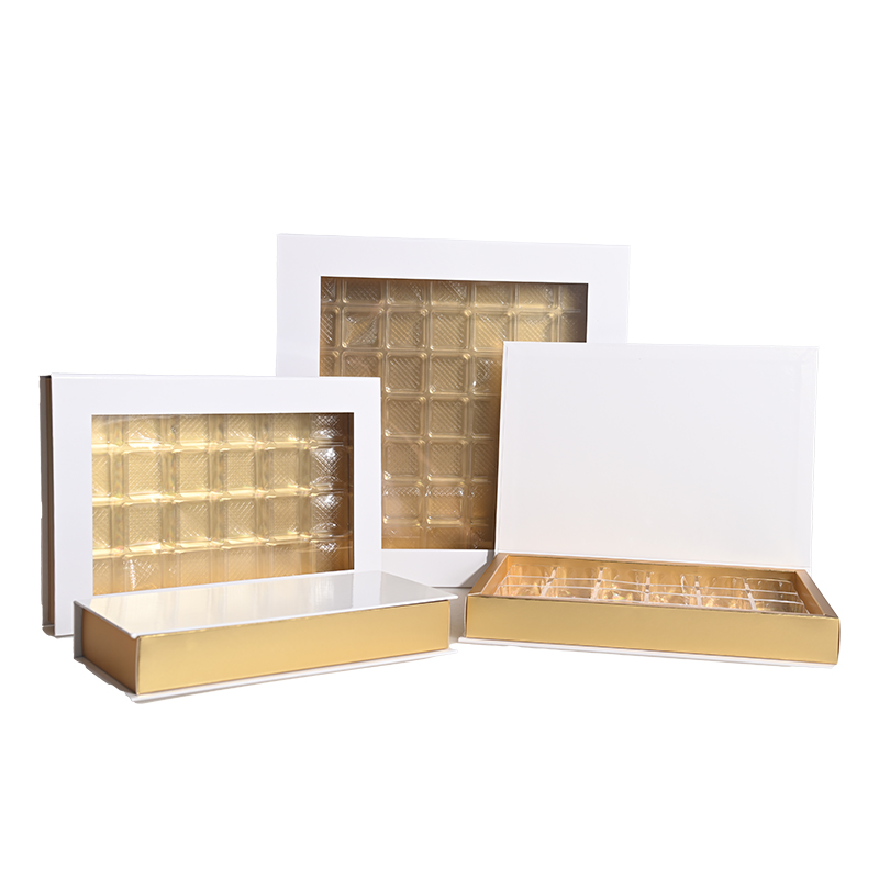 Individuelle, mehrteilige Verpackungsboxen für Schokolade in verschiedenen Größen mit goldenen Böden, weißen Deckeln und transparenten Sichtfenstern.
